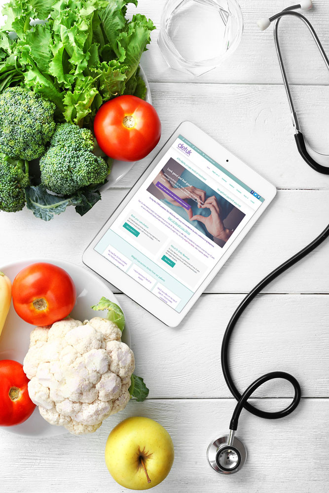Weight loss package graphic, ipad on a table with healthy food and stethoscope.